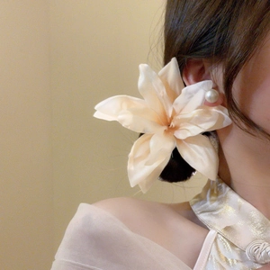 Detail of fabric lily flower hair clip with pearl on woman in elegant side view