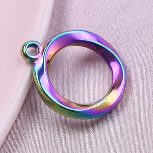 Macro shot of circular rainbow stainless steel pendant with irregular hollow design