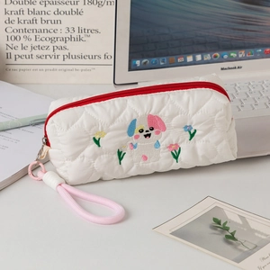 Detail of white quilted pencil case with heart texture, dog embroidery and pink lanyard