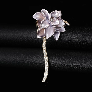 Detail of purple enamel lotus brooch with gold stem and sparkling rhinestones