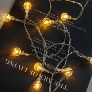 Warm white LED bubble ball fairy lights arranged on a stylish black artistic background