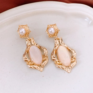 Detail of vintage French shell oval earrings with pink gems on a textured plate