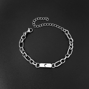Close-up of silver paperclip chain bracelet with engraved moon plaque and lobster clasp
