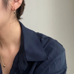 Minimalist gold heart necklace and teardrop earring set worn by a model in casual style