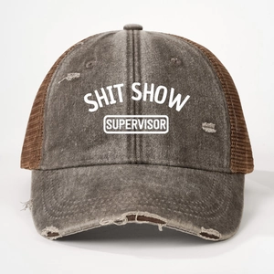 Close-up of distressed brown trucker hat featuring a Shit Show Supervisor printed slogan