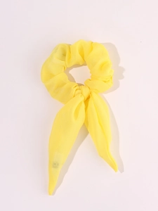 Detailed view of yellow tulle hair scrunchie with long streamers and built-in LED lights