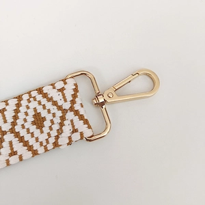 Close-up of brown and white geometric woven strap with golden alloy swivel lobster clasp