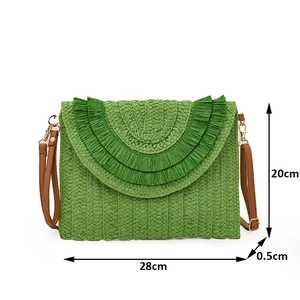 Detail view of woven raffia envelope bag in green with dimensions and leather strap