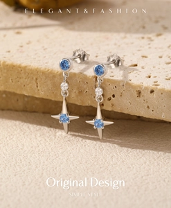Détail de boucles d'oreilles étoile en argent avec gemmes bleues et accents brillants