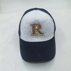 Close-up of black and white baseball cap with gold rhinestone letter R on breathable mesh