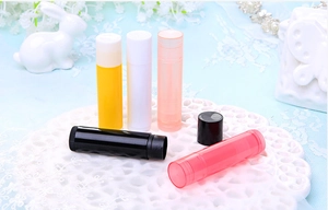Detailed view of empty 5g plastic lip balm tubes in various colors on a soft background