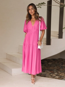 Detail of hot pink V-neck midi dress with puff sleeves and textured fabric for summer