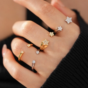 Détail d'une bague étoile en plaqué or 18k avec zircon sur main avec texture tricotée