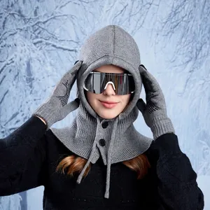Grey winter knitted balaclava hood and matching gloves set worn in snow scenery