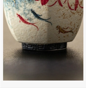 Macro detail of the smooth ceramic flat base and koi fish patterns on the teacup