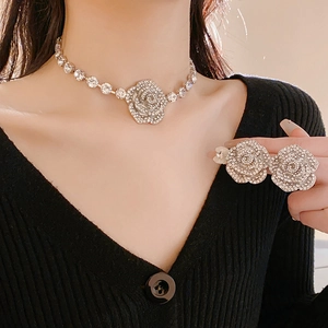 Gros plan détaillé du collier fleur de camélia étincelant et de la parure de bijoux