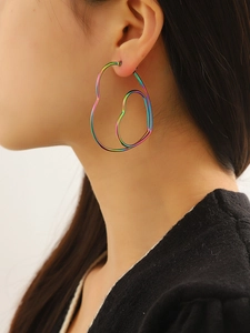 Détail macro de grandes boucles d'oreilles créoles cœur en acier inoxydable arc-en-ciel