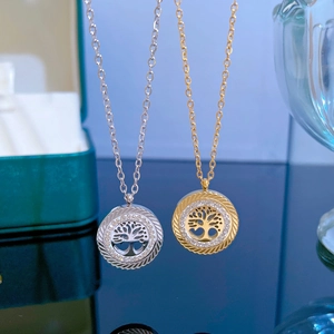 Detail of gold and silver tree of life pendants with sparkling zircon stone accents