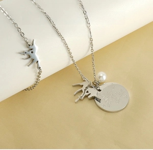 Detail of unicorn pendant necklace and bracelet set with engraved motivational charm