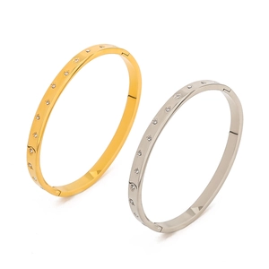 Detail of gold and silver stainless steel bangles with star-set zircon inlay craft