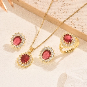 Macro detail of elegant gold jewelry set featuring red oval gemstones and crystal accents