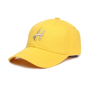 Détail d'une casquette de baseball en coton jaune avec broderie 3D argentée de la lettre H