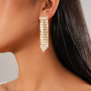 Détail de boucles d'oreilles pompons plaquées or 18 carats avec zircons sur modèle