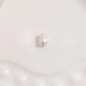 Macro shot of S925 silver cylindrical bead with textured grid pattern for DIY jewelry