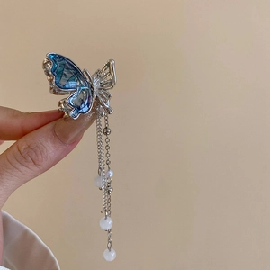 Détail de la pince à cheveux papillon bleu avec perles et longs glands métalliques