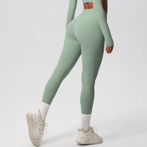 Detail view of sage green high-waisted yoga leggings with seamless shaping and lift effect