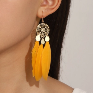 Detail of bohemian long yellow feather earrings on a model showing ethnic fashion style