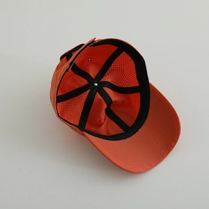 Détail intérieur de la casquette orange avec fentes en maille et bandeau de sudation