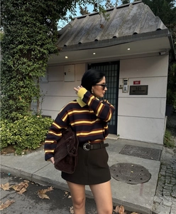Detail eines gestreiften Strickpullovers mit Polokragen und strukturierter Strickoberfläche