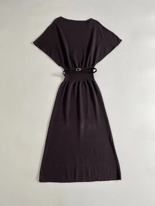 Flat lay of a dark knitted midi dress with batwing sleeves and matching metal buckle belt