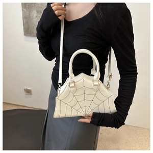 Detailed view of white spider web handbag with black embroidery and versatile straps