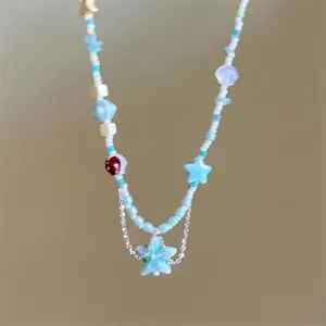 Detail of beaded necklace featuring marble stars, seashell and colorful pendant