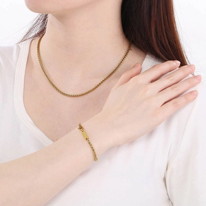 Nahaufnahme der vergoldeten Edelstahlkette und des Armbands an einem Modell getragen