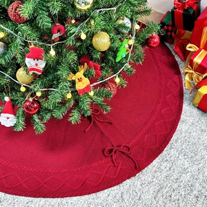 Détail de la jupe de sapin de Noël rouge en tricot torsadé avec liens sous le sapin