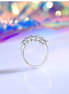 Close-up of sparkling oval-cut stones set in a polished silver eternity band ring