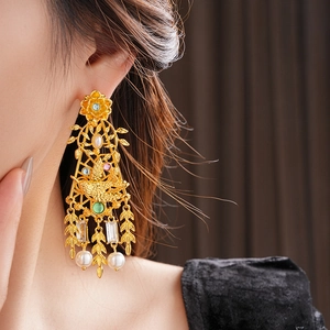 Detalle de pendientes vintage con cristales de colores y borlas de perlas en una modelo
