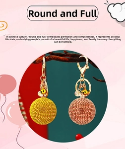 Detail of rhinestone encrusted sphere keychains with golden bells and lobster clasps