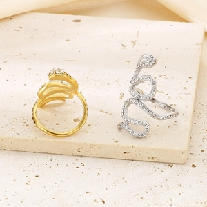 Nahaufnahme von Schlangenringen in Gold und Silber mit Zirkonia auf Travertinstein