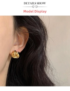 Detailed view of golden twisted knot stud earring worn by a model to show size and scale