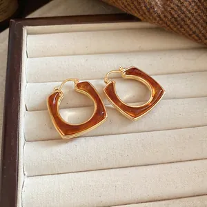 Vintage 18k gold plated resin square hollow earrings on elegant jewelry display
