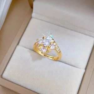 Macro detail of gold flower ring with brilliant zircons on a velvet jewelry box
