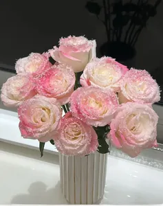 Dettaglio di rose sfumate rosa con effetto neve ghiacciata in un vaso di ceramica