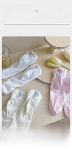 Close-up of breathable mesh cotton socks featuring delicate bow embroidery and honeycomb texture