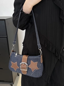 Detail of vintage denim shoulder bag featuring brown leather stars and silver buckle