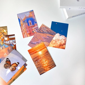 Detail view of sunset aesthetic postcards with artistic quotes on a white desk