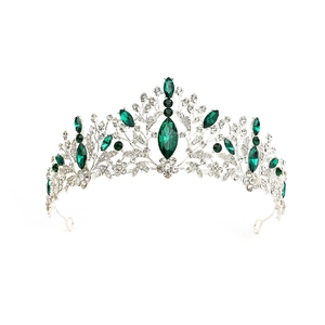 Detailed close-up of a silver baroque tiara featuring marquise green emeralds and crystals